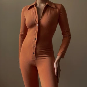 Vintage Katharine Hamnett Jumpsuit - Vintage Jumpsuit Made In Italy With Body Hugging Details. Metallic Colored Buttons And A Zip Front Closure. Thick Cotton Fabric Smooths Curves Of The Body. Excellent Condition.  Model Is 160cm (5”3) And Generally Fits XS/S.   90% Cotton 10% Spandex