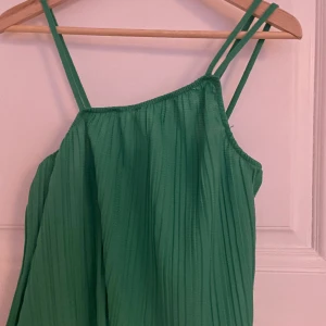  Asymmetrisk grön topp från bikbok - En super fin grön sommar topp som är använd 1 gång! Är i storlek XS men passar definitivt upp till M