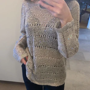 Stickad tröja  - Säljer min stickade tröja som oxkså är lite genomskinlig. Passar fint till middagar, fest, nyår o mycket mer. Säljer den för har ingen användning till den samt den är lite stor på mig. Den har paljetter. Köpt i Spanien.  Färgen är grå. 