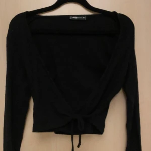 svart kofta/tröja med knytning - Använt några få gånger, lite kort så rekommenderas med ett mindre linne under 