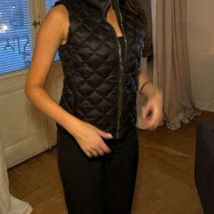 Svart väst - Svart väst från mango, inga skador perfekt skick, säljs för att den inte har kommit till större använding. Storlek XS !! Endast dessa bilder!!