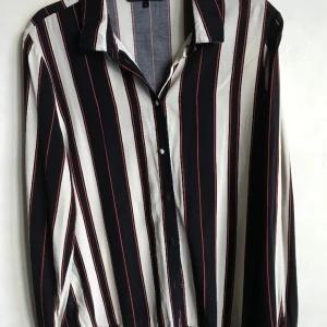 Vacker randig skjorta  - Svart, vit och röd randig ganska tunn skjorta från Vero Moda. Knappar framtill och vid ärmarna. Obetydligt använd hel och ren. Skön mot kroppen storlek L 