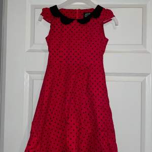 Jätte fin röd klänning med svarta prickar och en svart underkjol. Det är en liten dragkedja i ryggen och ett svart band som man knyter. Den kosta 500kr ny. Säljer eftersom den är för liten. Den är bara använd vid fåtal tillfällen. 