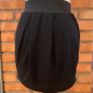 Svart kjol i 100% polyester  Helfordrad  Strl M Från BikBok  Bred resår i midjan  Modellen heter DKS BUDDAH