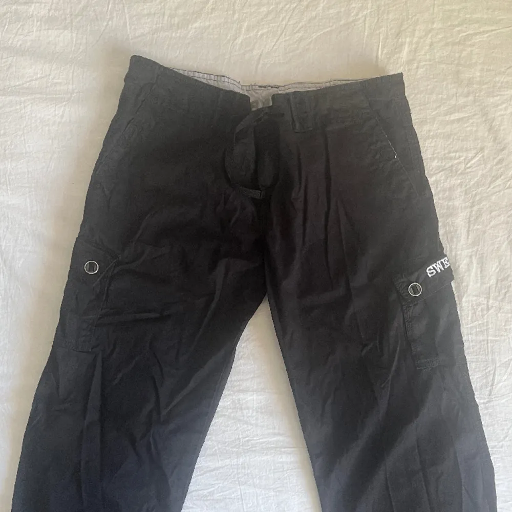 svarta lågmidjade cargos. Märkt L men passar även mig som är xs då man kan knyta i midjan.. Jeans & Byxor.