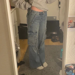 Lågmidjade cargo jeans - Lågmidjade cargo jeans från Zara. Jag är 174cm. Midjemått 74cm Innebenslängd 83cm
