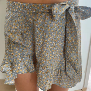 Kjol - Supergullig kjol med blommigt mönster. Man ”knyter ihop” den och kan därför sätta den lite som man själv vill. Kjolen är i storlek S. Använd fåtal gånger så mycket fint skick! Hör av dig vid frågor eller önskemål om fler bilder💚