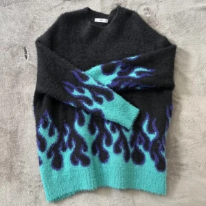 Stickad tröja  - Mysig stickad tröja med blåa eldflammor, storlek S men passar även M