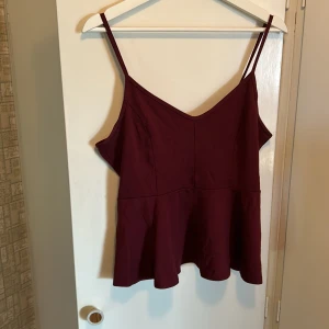 Linne - Vinrött linne med lite volang och fin urringning, använt skick men fin.