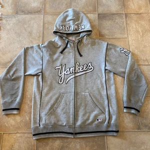 New york yankees Hoodie - Det är en väldigt sällsynt och eftraktad Hoodie gjord och köpt i New York, den har tryck på armen,bröstet och luvan, den har ett litet hål på ryggen som syns knappt när man har på den, därav priset! Annars en jätte fin tröja👍