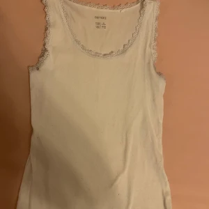 Vit ribbad linnetopp från Esmara - En vit ribbad linnetopp från Esmara med spetsdetaljer runt halsringningen och ärmhålen. Toppen är ärmlös och har en tight passform. Skriv om ni har några frågor 💕