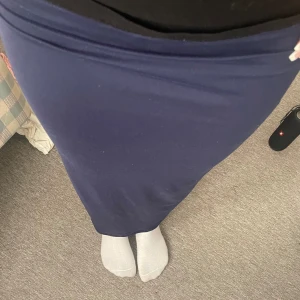 Blå långkjol - Jag säljer min blåa långkjol för jag inte tycker den passar min stil så mycket. Den är helt oanvänd endast testad. Det medföljde även en blå kort t-shirt i samma färg som man får med på köpet. Den går hela vägen ner och har ett stretchigt material.