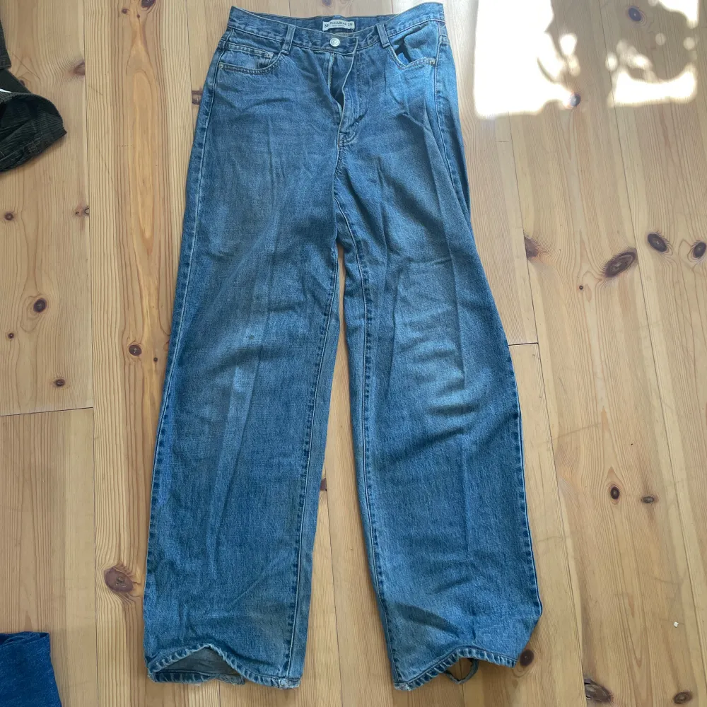 Baggy jeans, fläckad med grön färg på två ställen vid knäna, hål vid fotändan . Jeans & Byxor.