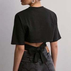 Svart topp - Säljer denna svarta toppen med knytning från Nelly i storlek S. Aldrig använd. Slutsåld i storlek S på deras hemsida 🙌