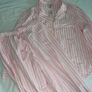Victoria seceret rosa pyjamas - Rosa skjortpyjamas med vita ränder i helt nytt skick i storlek S men passar även XS. Jättesöt och fin och prislapp finns även kvar. Pris kan diskuteras 