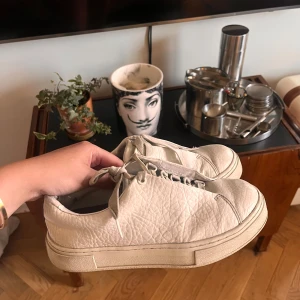 Vita sneakers - Ett par vita sneakers med snörning från Eytys. Skorna har en slät och något skrynklig yta och en tjock sula. De är i välanvänt men bra skick.