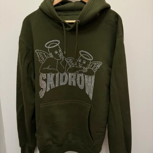 Skidrow hoodie - En mörkgrön skidrow hoodie med mönster gjort av paljetter.