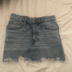 jeans kjol  - resor band i bak, men töjs ut och syns inte  när man sätter på sig kjolen 