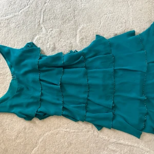 Festklänning  - Superfin grön volangklänning med pärldetaljer. Köpt i en vintageaffär