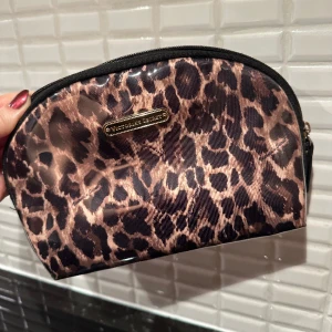 Victorias Secret necessär - Ca 20x15x5 cm, i fint skick! Lite orättvist ljus - färgen/mönstret är mer som necessären på sista bilden (annan modell, alltså enbart med för o få rättvis färg/mönster). 