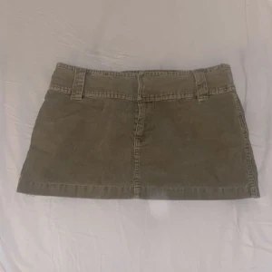 Lågmidjad kjol - Söt lågmidjad minikjol i ljus olivgrön manchestertyg💕 Passar M, möjligen en liten L. Skriv vid funderingar och kolla in mina andra annonser🪩🎀