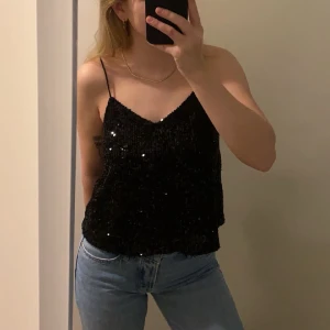 Glittertopp - Säljer nu denna fina festtopp från Vero Moda, jättefin glittertopp som aldrig använts. Storlek XS men passar mig som brukar ha M i toppar