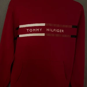 tommy hilfiger röd tröja - bra kvalite på denna tjocktröja dock lite missfärgning på snörena därav det billiga priset, hör av er vid intresse!!