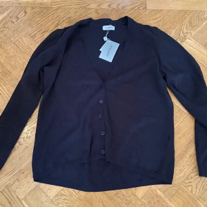 Hunkydory cardigan strl M - Helt ny cardigan från Hunkydory. Felice cardigan. Färg Dark evening black. M = ca 38-40. V-ringad. 100 % bomull. 