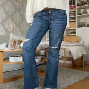 Lågmidjade jeans - Såå snygga lågmidjade jeans med slitningar i nyskick! Står ingen storlek men skulle gissa på 38/40, midjemåttet är 44cm💓