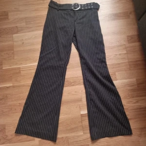 Randiga Kostymbyxor - Superfina randiga utsvängda, mid rise kostymbyxor i fint skick med inbyggt bälte. Köpta på Vinted men passade tyvärr inte och var lite för långa på mig. Inte mina bilder