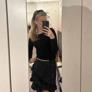 Svart kjol - En söt prickik kjol med volanger och dragkedja vid midjan! Passar perfekt till sommaren eller med strumpbyxor på vintern