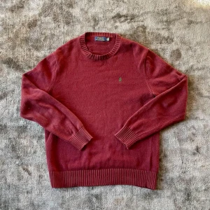 Ralph lauren tröja - Säljer en ass snygg stickad polo Ralph Lauren tröja i storlek M. I princip nyskick med inga hål eller fläckar eller andra tecken på användning. Den är i en vinröd färg med en Olive grön häst. Skriv vid eventuella frågor.  