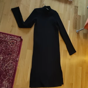 Svart ribbad klänning med polokrage, oanvänd  - Svart, ribbad klänning med polokrage. Svalt och känt tyg med slits i örm och nederkanten. Oanvänd.  Kan mötas upp i lund, annars står köparen för frakten 🌸