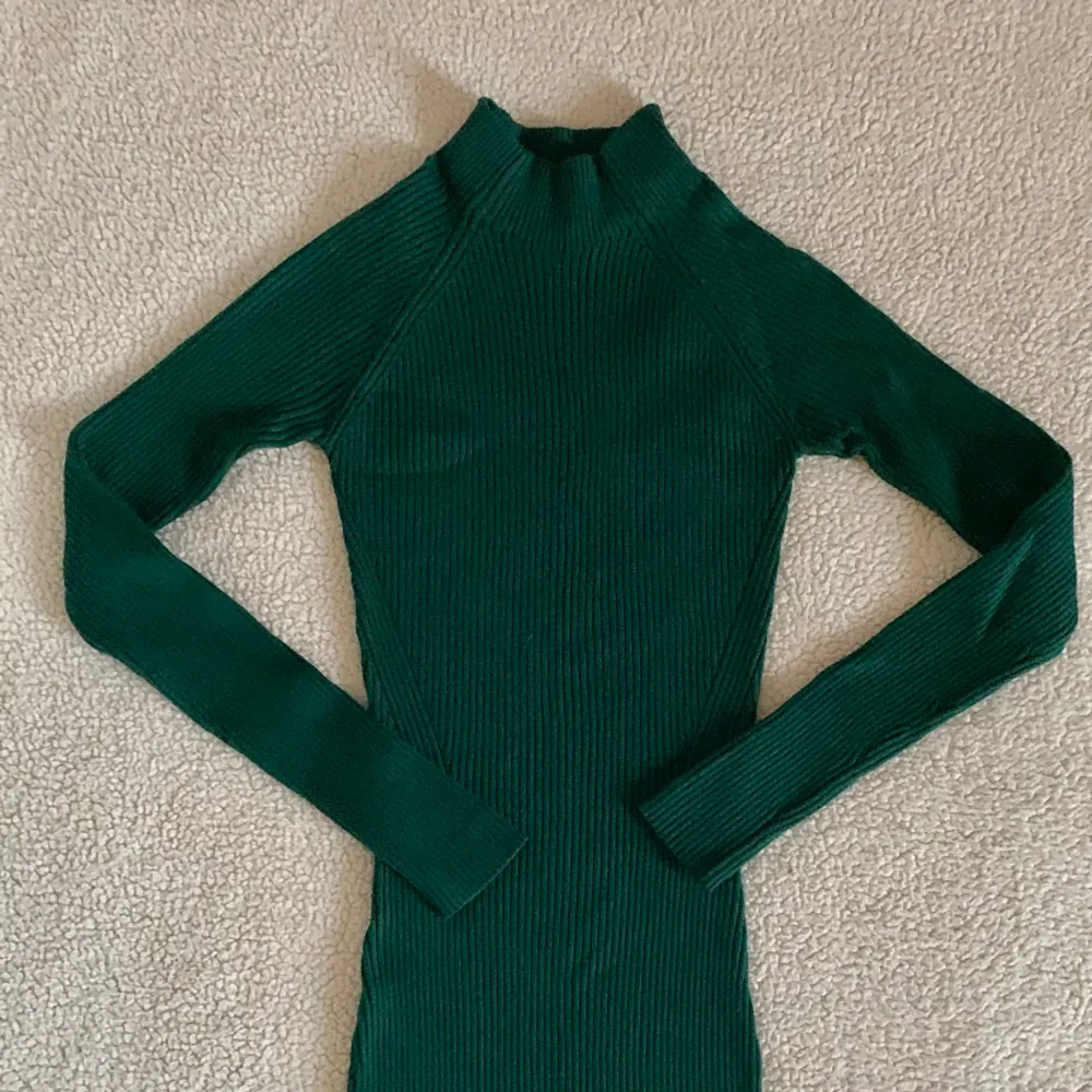 Otroligt vacker smaragdgrön ribbstickad klänning i midi-längd köpt på Mohito i Polen. Storlek XS men OTROLIGT stretchig ich bekväm och passar även S. Använd vid en julafton, utan anmärkningar. Nyskick.. Klänningar.