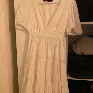Vit Zara Klänning - Säljer denna jättefina Zara klänningen med söta detaljer! Endast använd på midsommar för något år sedan. Liten fläck på framsidan som var där när jag beställde den, men som säkert går bort om man försöker. Fråga gärna om du undrar något💘💘