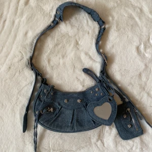 Denim handvöska - Denimhandväska med nitar. Köpt second hand och det finns inga lappar så vet tyvärr ej märket💞