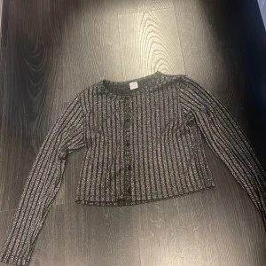 En glittrig långermad tröja -  väldigt bra skick då den är använd 1-2 gånger då den var för liten för min 12 åriga dotter