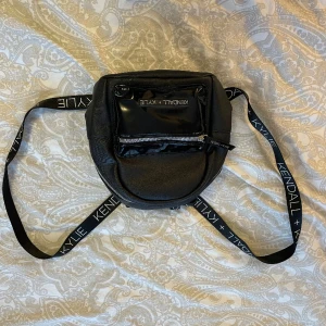 Svart ryggsäck liten - Text på banden: kylie+ kendall