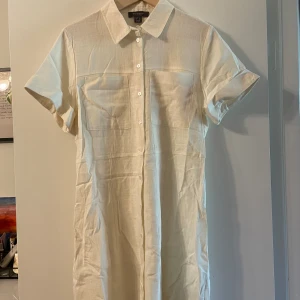 Somrig linneklänning (oanvänd) - En somrigt klänning i linnematerial, modellen är skjortklänning, lite kortare. Funkar också som öppen kofta om man vill det. Endast använd vid några enstaka tillfällen! 