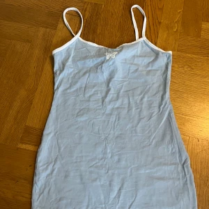 Blå klänning - Blå tajt klänning med en vit liten fjäril, knappt använd och perfekt till sommaren