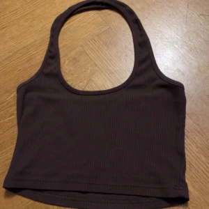 Brun halter neck top - Säljer denna bruna halter neck top för den inte kommer till användning, perfekt till sommaren och knappt använd