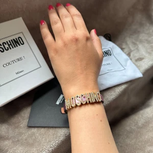 Moschino läderarmband!! 💕 - Jättefint moschino armband!!💕 I nyskick aldrig använt. Äkthetsbevis finns i form av tag. Köpt på NK i Stockholm. Allt på bilden medföljer. Skriv vid frågor eller fler bilder!!💞