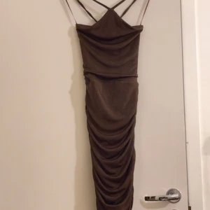 Klänning  - En klänning från bikbok, med öppen rygg som man knyter. Aldrig använt och är i bra skick. Passar till fester men även vardagliga saker. Den hamnar precis under knäna men man kan också justera som man vill. Ej genomskinligt. Frakt ingår med 29kr. 