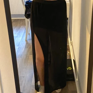 Svart kjol  - Svart kjol med slits på båda sidorna, den har en under kjol 