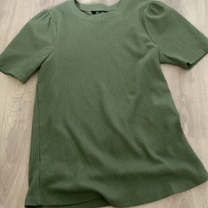 T-shirt  - En grön ribbad t-shirt🛍️ Bra i storlek🙏 Skön och fin💞 Säljer den för jag inte använder den längre✌🏻💗📦 Skriv för mer information❤️