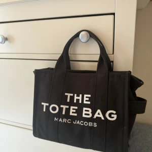 the tote bag, Marc Jacobs - Säljer min jätte fina Marc Jacobs THE TOTE BAG, som knappt är använd då jag har många andra väskor som jag använder. Nypris på väskan är 2500. Ena spännet på väskan är dock sönder men är lätt att laga om man går till en skomakare. Pris kan diskuteras