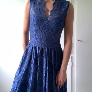 Blå kortärmad broderad klänning. - Dragkedja i sidan. Använd 1 gång.