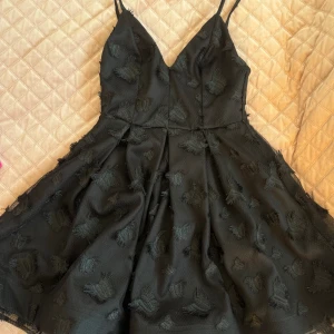 Kort klänning - En kort svart klänning med fjärilar. Ej använd.