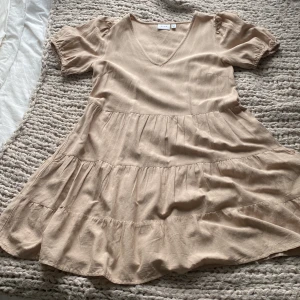 Super fin klänning från Vila!💞 - Säljer denna fina klänning från vila eftersom att jag rensar garderoben och har inte plats. Den är i nytt skick och endast använd 3 gånger. Den är beige/brun och har fickor! Priset går att diskuteras!!!