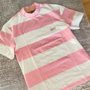 Cortiez striped tee - Heej! Jag säljer en helt oanvänd  T-shirt i snygg rosa och vit randig design från märket Cortiez. Tröjan är perfekt för dig som älskar att sticka ut med stilen och levereras i sin orginalförpackning. Tveka inte att höra av er vid intresse/frågor.🤩😊